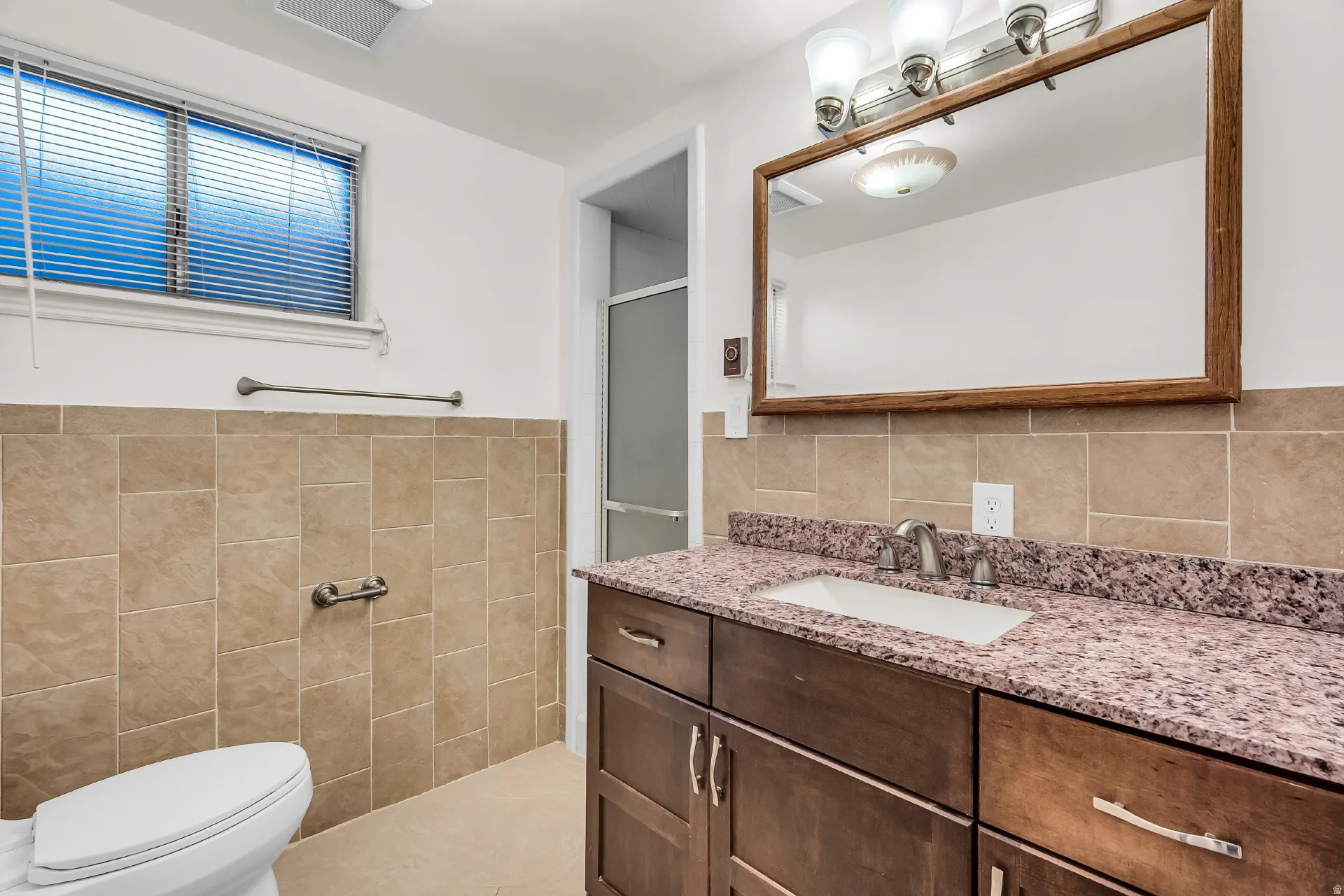 Wood-finish vanity with an integrated sink and light-toned countertop