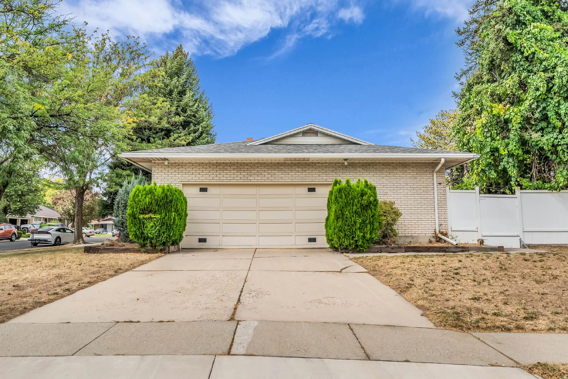 Brick exterior featuring a two-car garage and a paved driveway