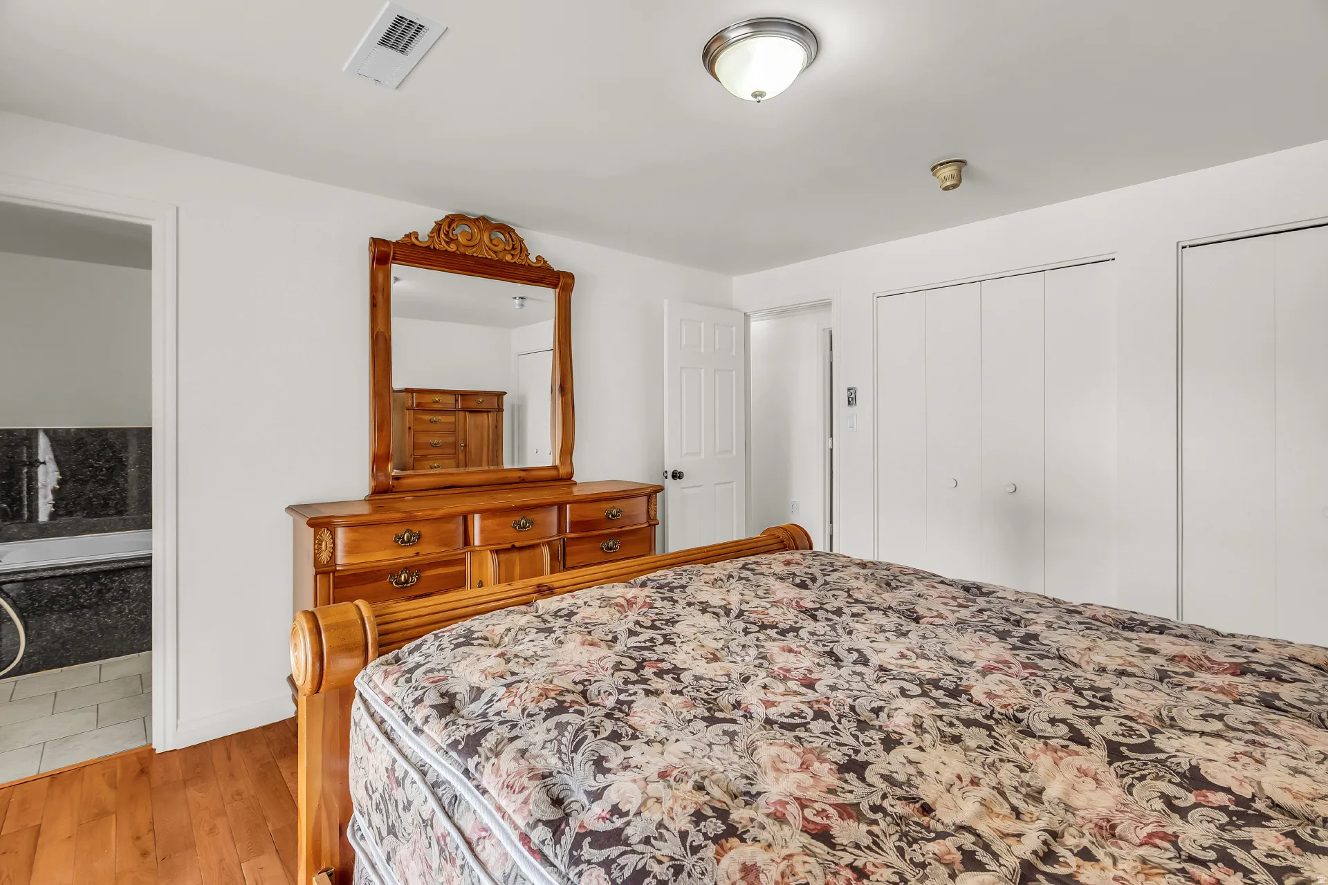 Hardwood-finish flooring, recessed ceiling light fixture, and built-in closet storage