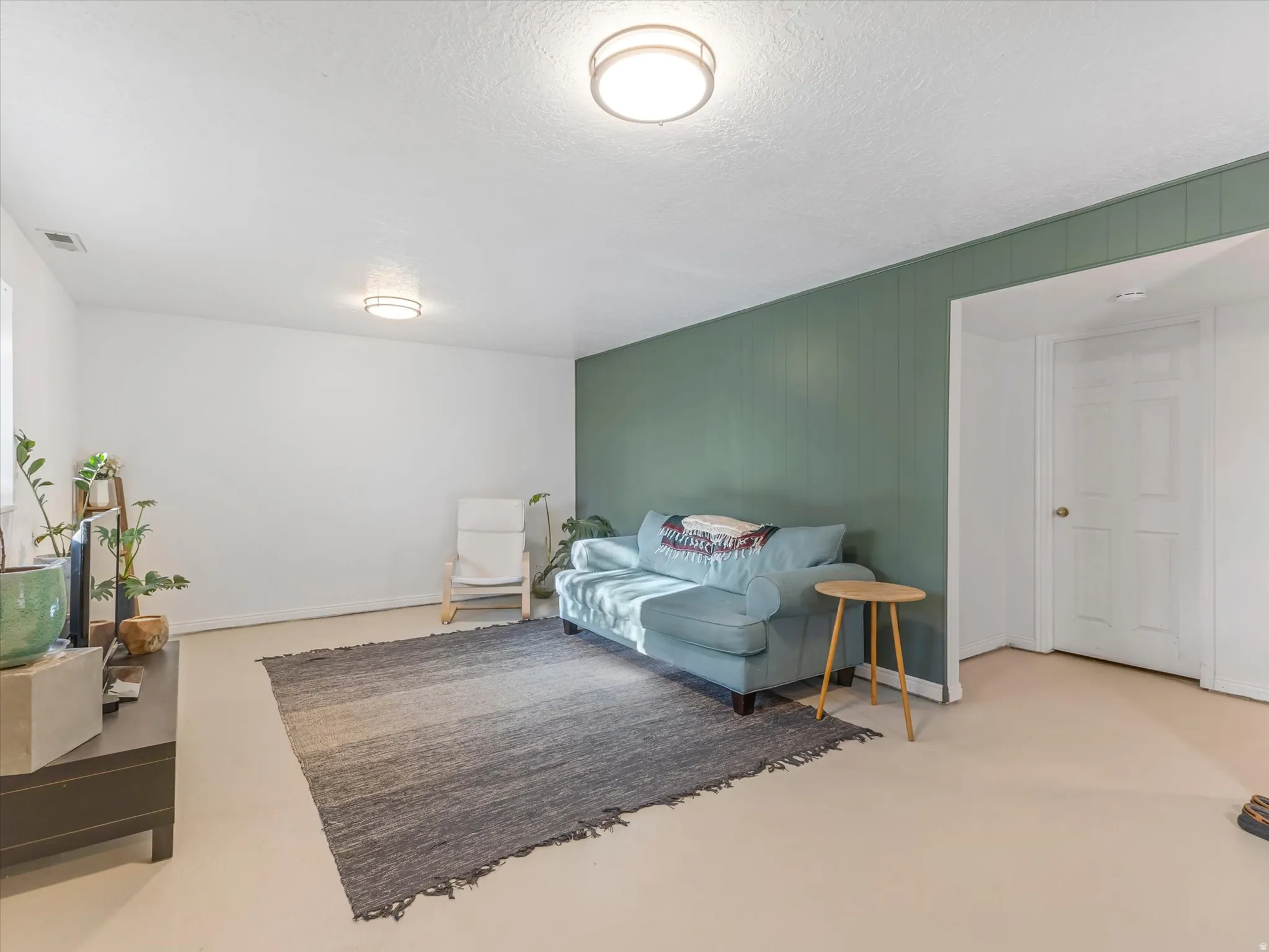 Light-toned flooring, recessed lighting, white walls, and a feature wall with vertical paneling