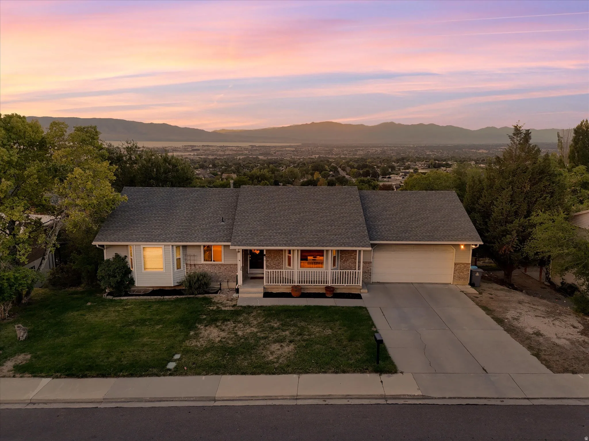 Traditional-style residence with an attached garage, covered front porch, and a paved driveway