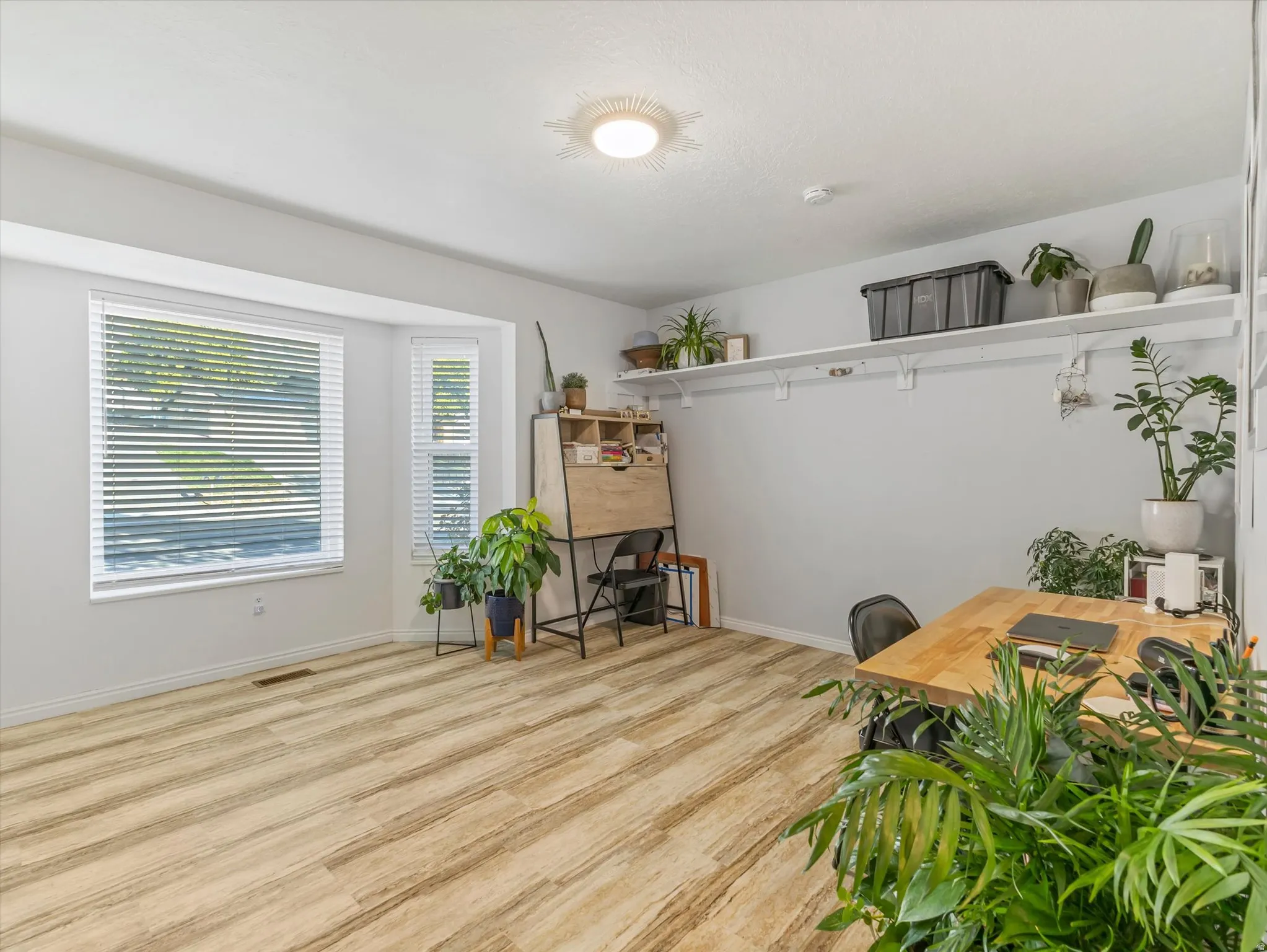 Wood-finish flooring, multiple windows, built-in shelving, and recessed lighting