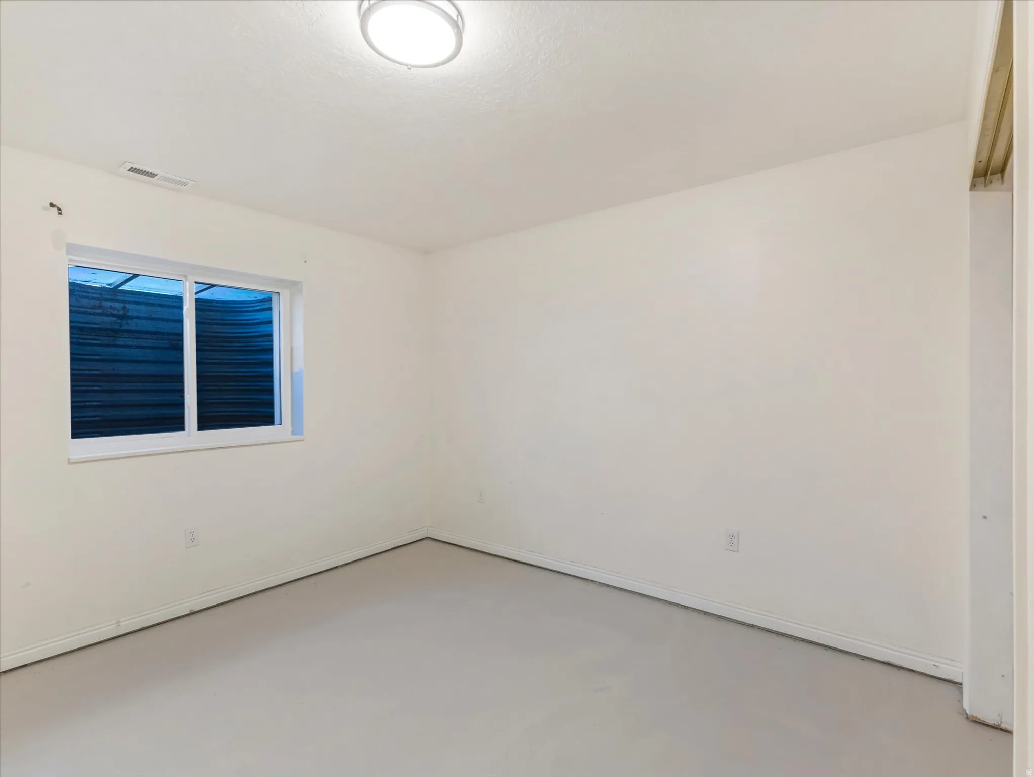 Recessed window with white trim, flush-mount ceiling light, light-toned flooring, and neutral wall tones