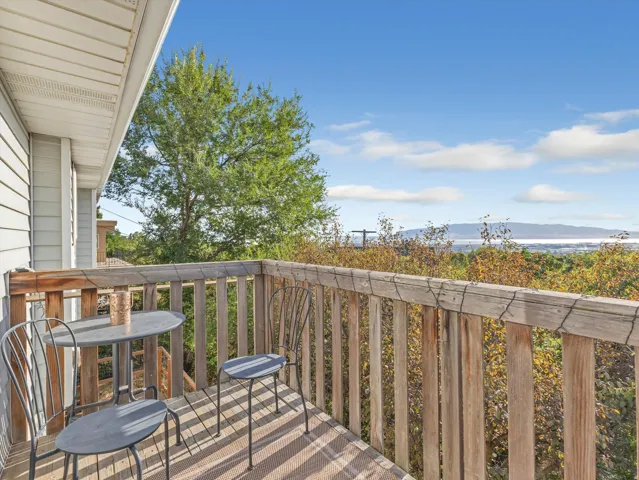 Balcony with wood railing, composite decking, and distant water scenery
