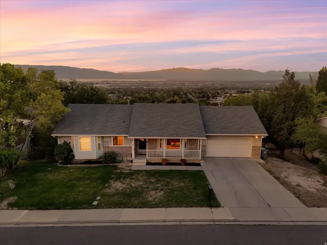 Traditional-style residence with an attached garage, covered front porch, and a paved driveway