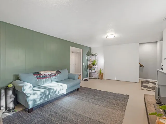 Panel wall accent, recessed lighting, wood-finish flooring, staircase with wood railing, interior door