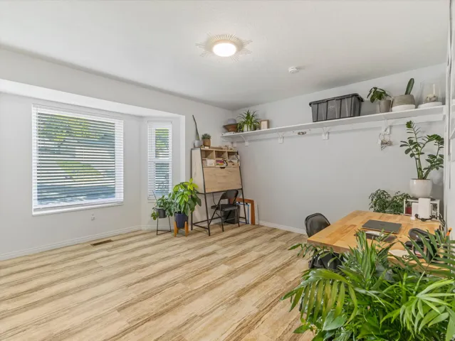 Wood-finish flooring, multiple windows, built-in shelving, and recessed lighting