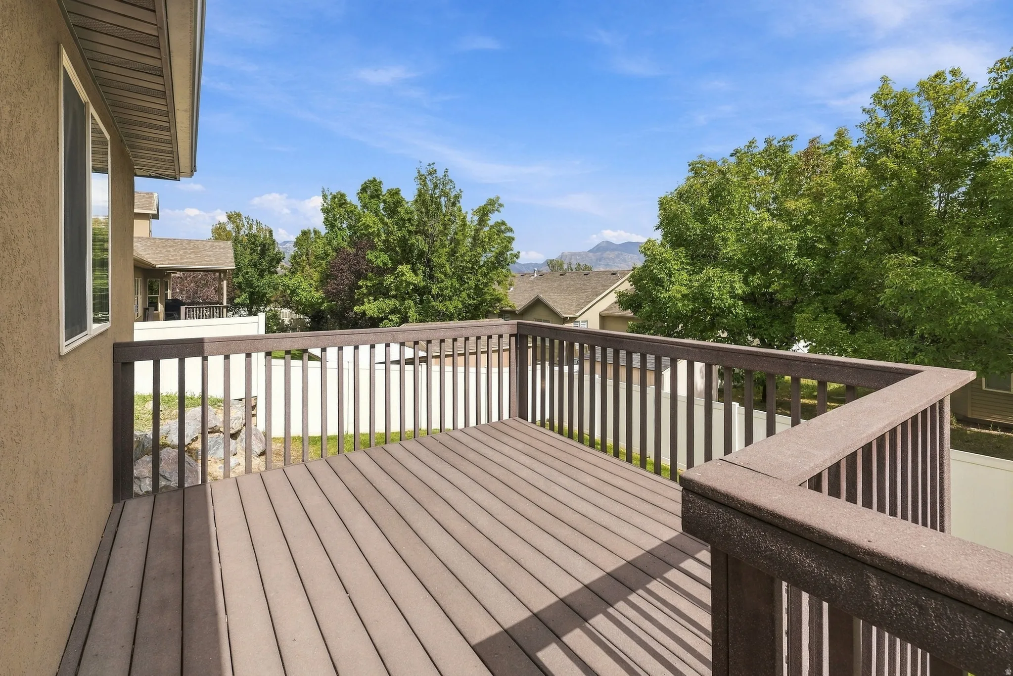 Outdoor deck with composite decking and railing, and surrounding mature trees