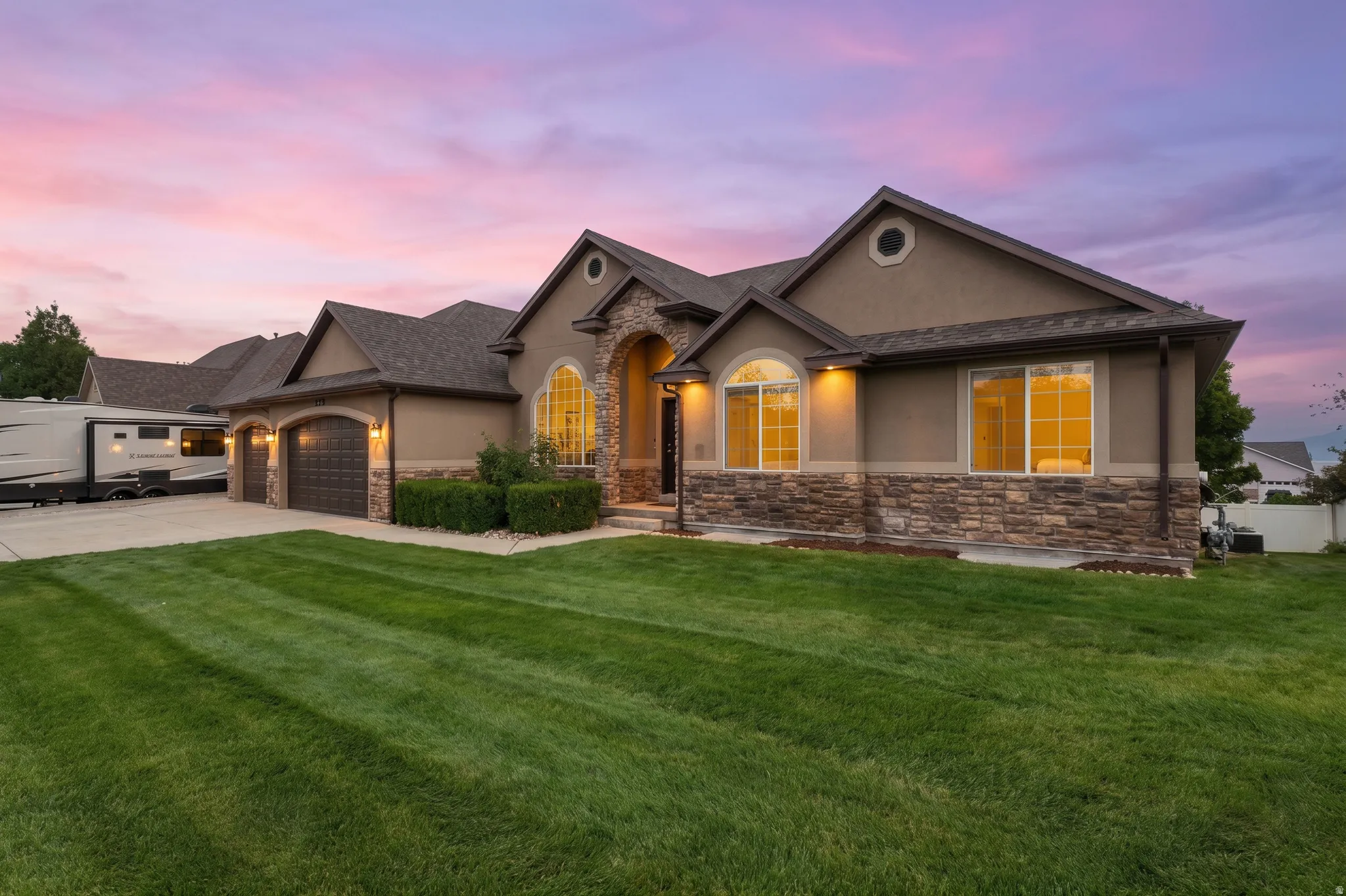 Rambler home with stucco and stone exterior with arched entry