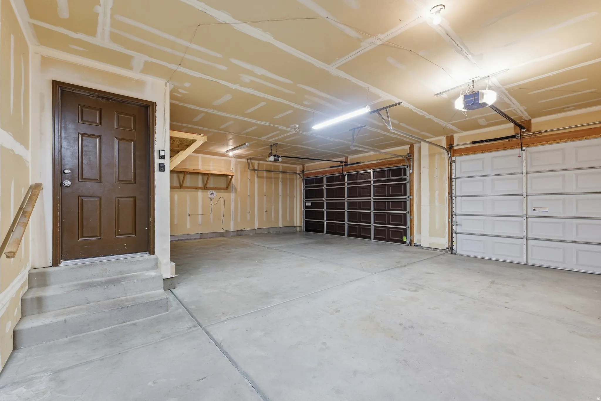 Attached three-car garage with bonus depth. Has concrete flooring and built-in shelving