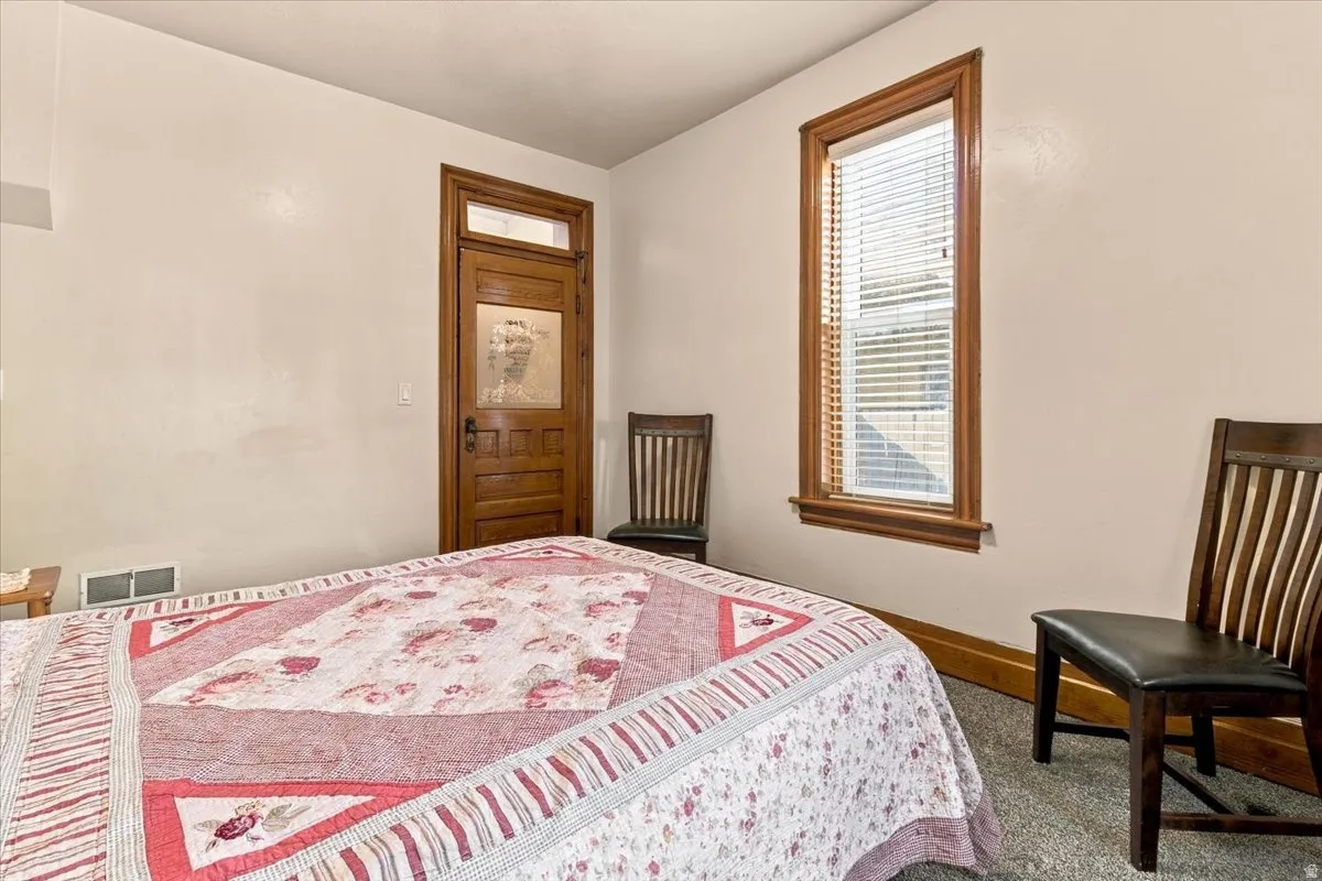 Wood-frame door with glass paneling, wood-trim window, and light-colored wall paint