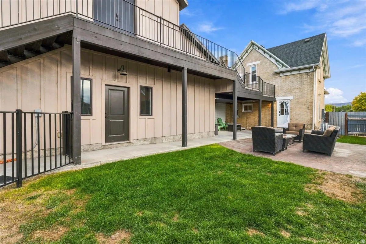Expansive outdoor patio with patterned hardscaping and a manicured lawn