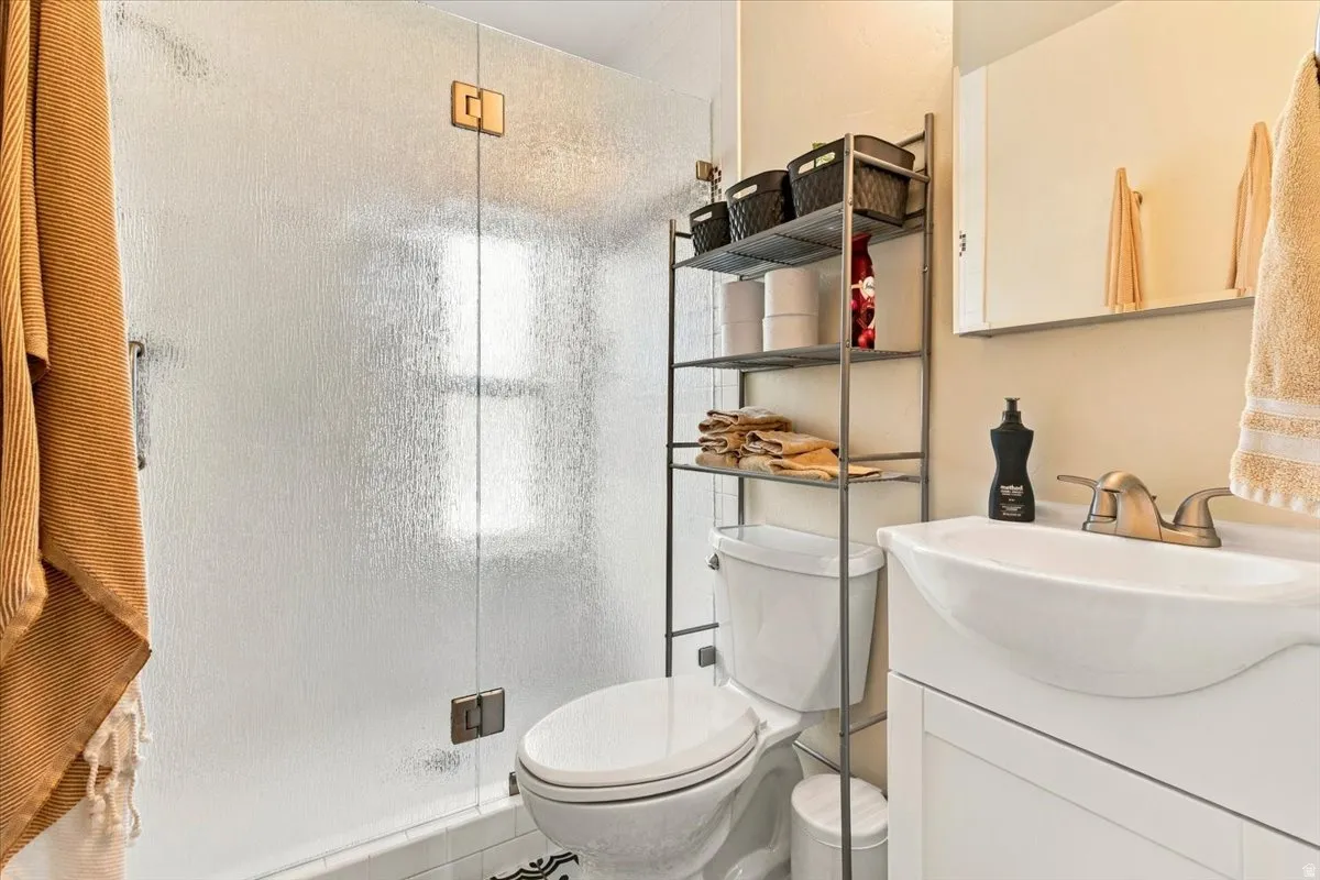 White vanity with integrated sink, bronze-finish faucet, and coordinating wall-mounted storage