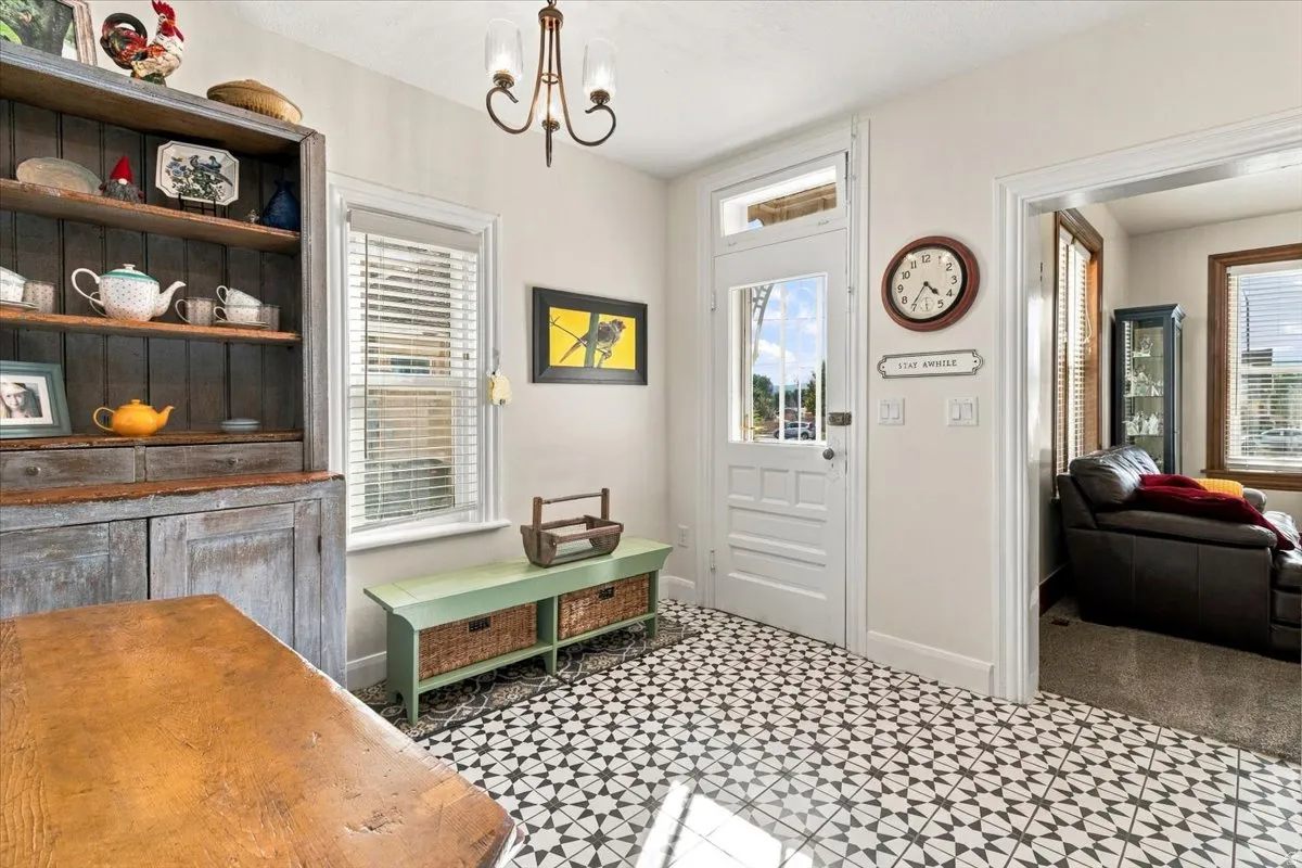Patterned tile flooring, a transom window over the entry door, and a decorative chandelier