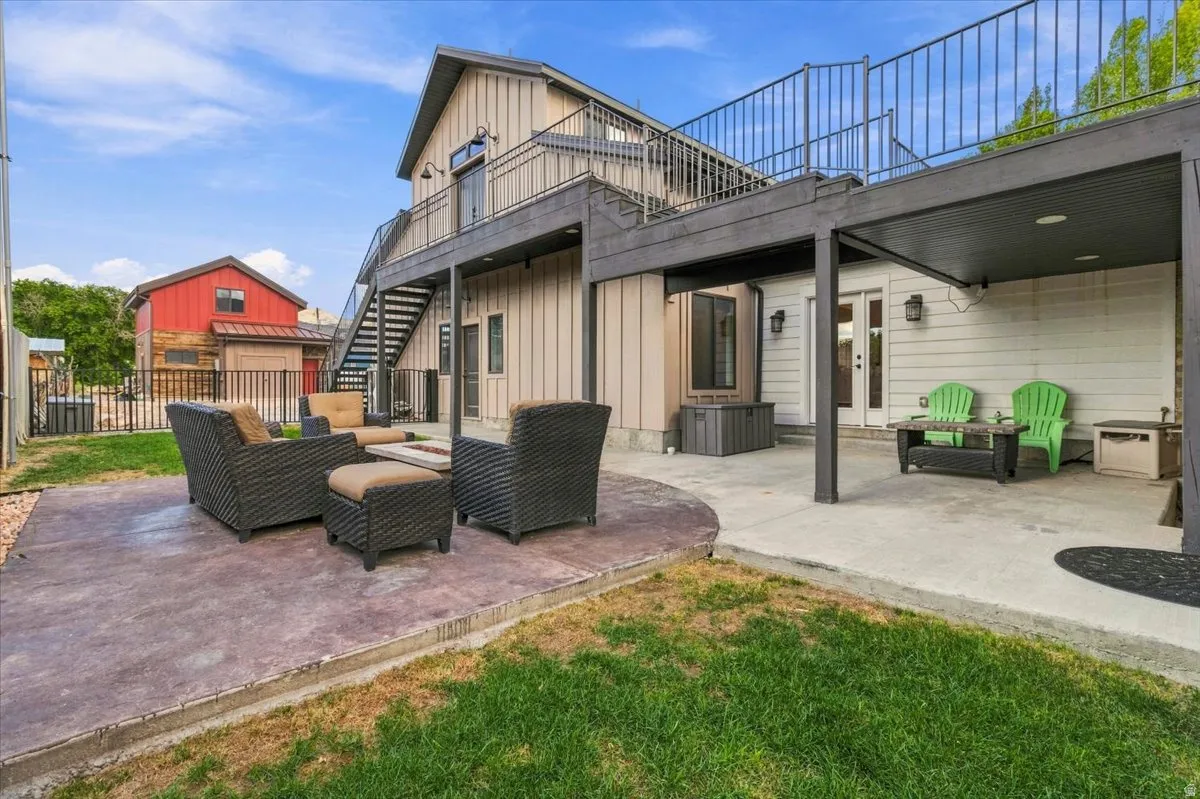 Multiple outdoor patio areas, a covered lower patio, and a second-level balcony with metal railings