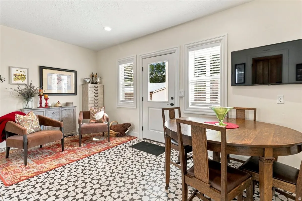 Patterned floor tile, white interior door, recessed lighting, and white window blinds