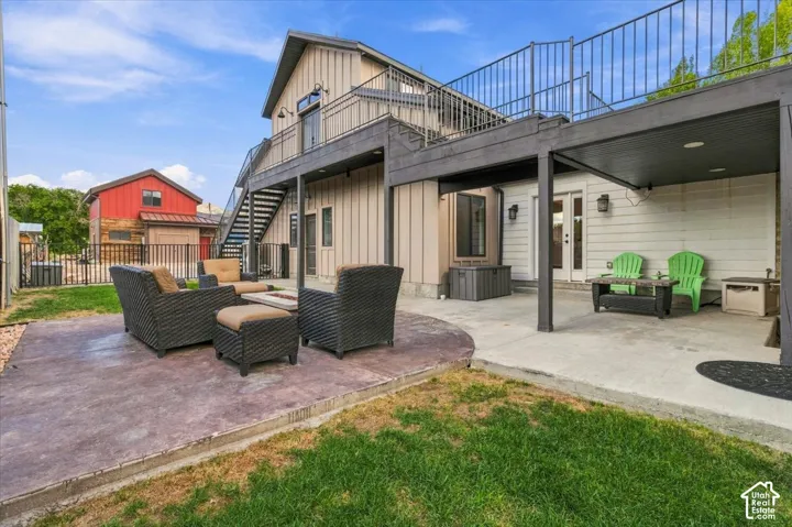 Multiple outdoor patio areas, a covered lower patio, and a second-level balcony with metal railings