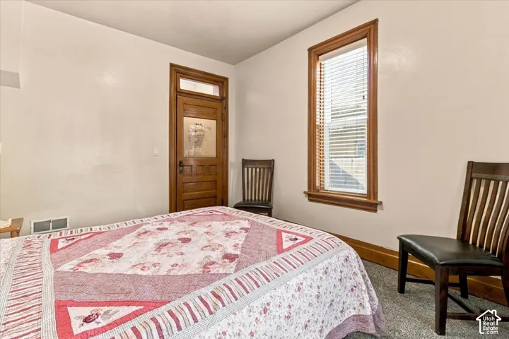 Wood-frame door with glass paneling, wood-trim window, and light-colored wall paint