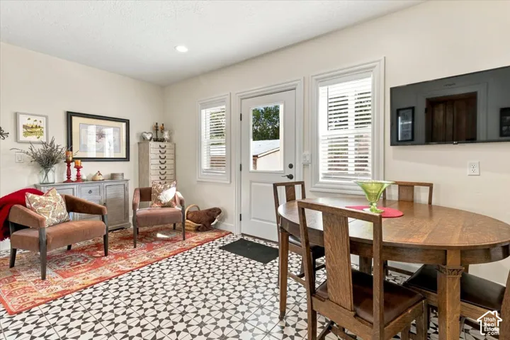 Patterned floor tile, white interior door, recessed lighting, and white window blinds