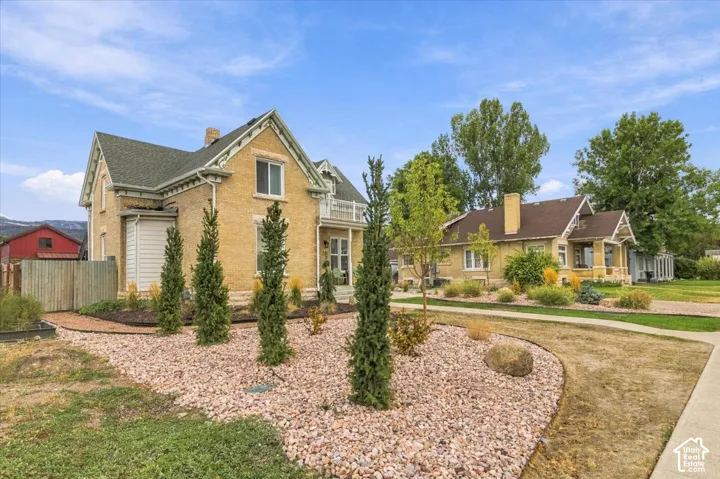 Brick exterior with decorative gables and white trim, featuring a covered porch