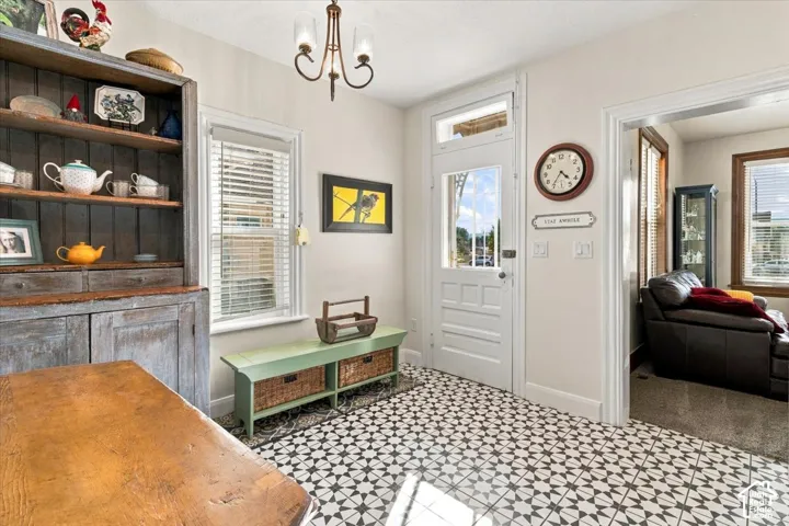Patterned tile flooring, a transom window over the entry door, and a decorative chandelier