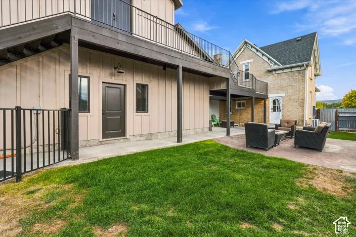 Expansive outdoor patio with patterned hardscaping and a manicured lawn