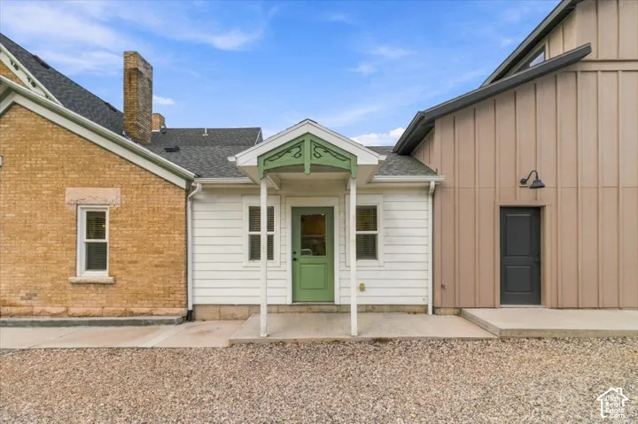 Brick and horizontal siding exterior with a dark shingle roof