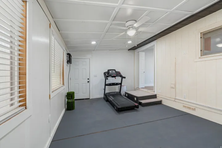 Recessed lighting, ceiling fan, white paneled walls, and durable flooring