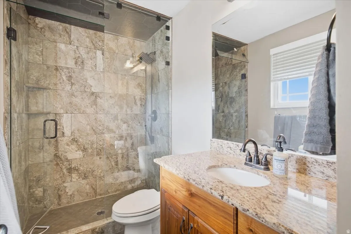Frameless glass shower enclosure with tiled walls, shower niche, and rain showerhead