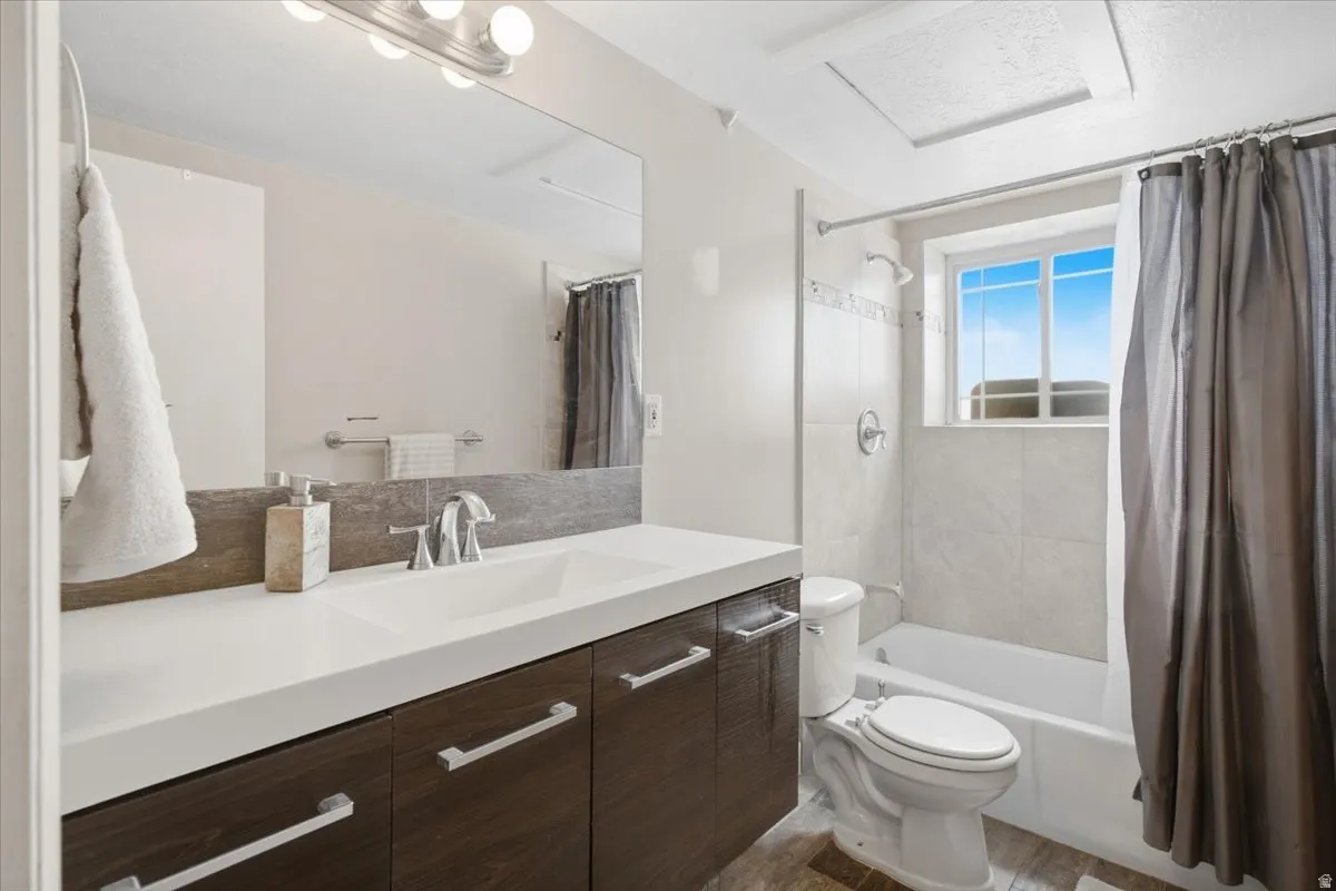 Vanity with integrated sink, wood-finish cabinetry, and chrome hardware