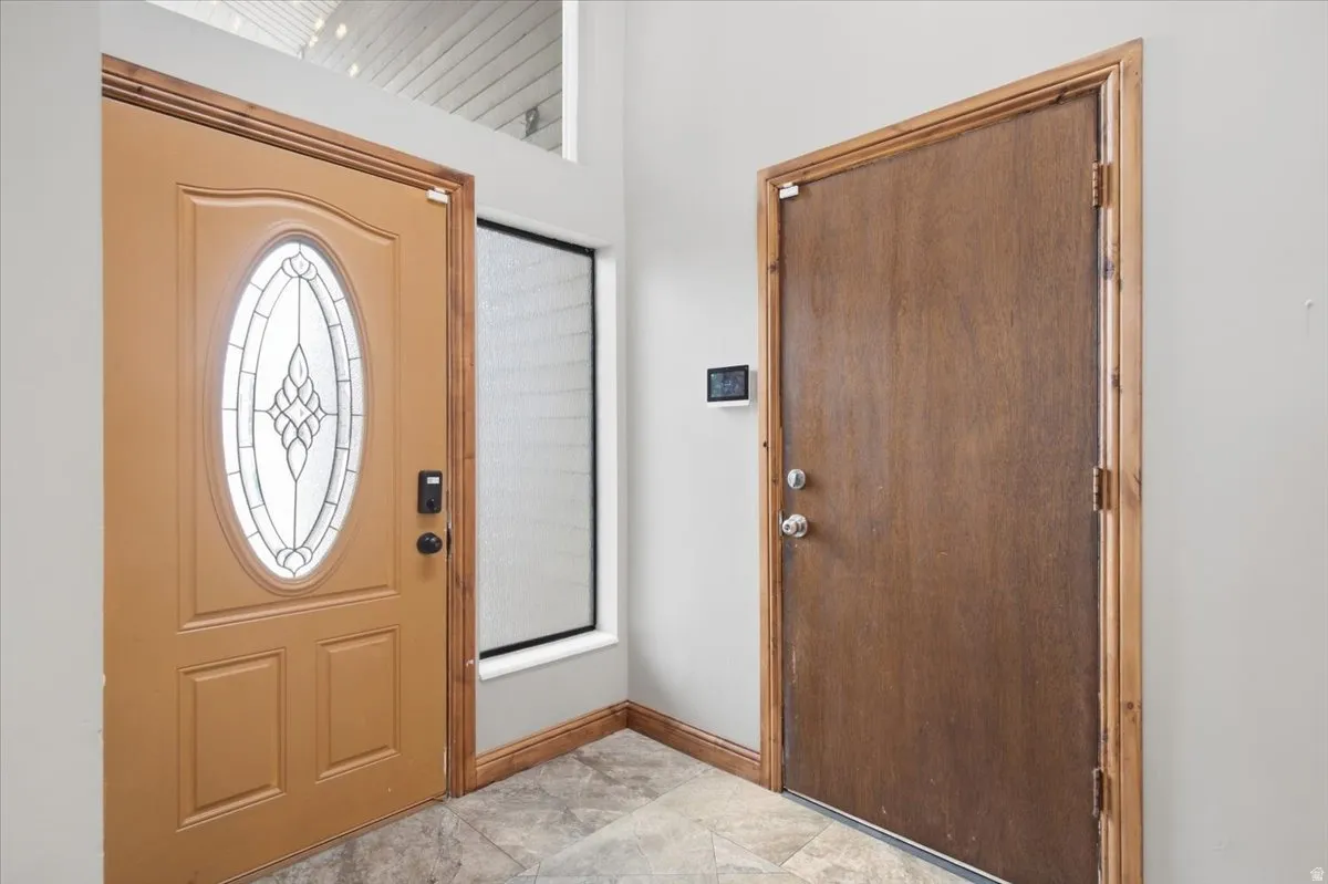 Entryway featuring a decorative glass oval door, tile flooring, and light-colored wall paint