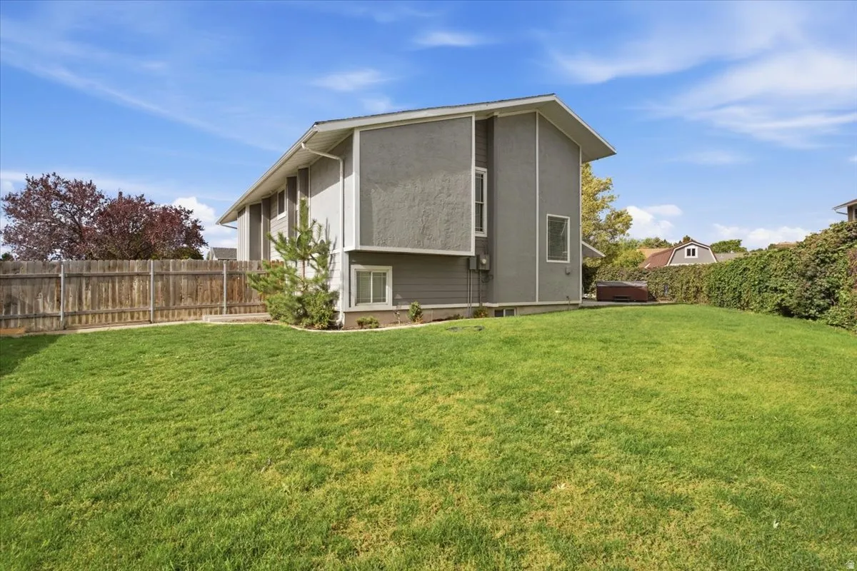 Expansive green lawn with a wood-fenced perimeter