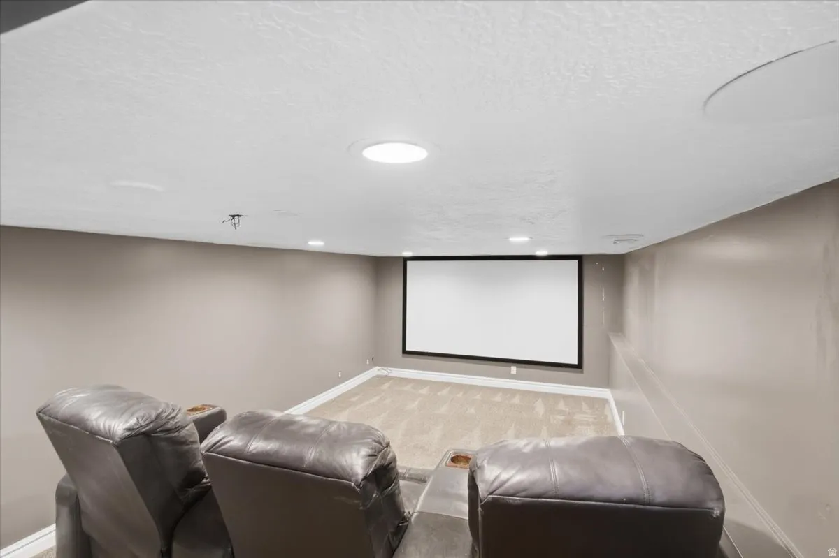 Built-in projector screen with recessed lighting and a round ceiling light