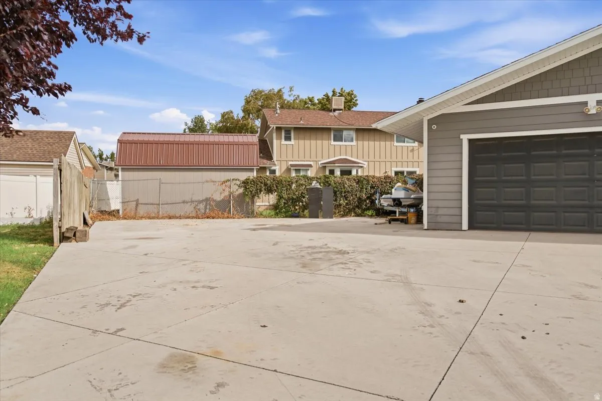 Paved driveway leading to a two-car garage with horizontal siding and shake siding accents