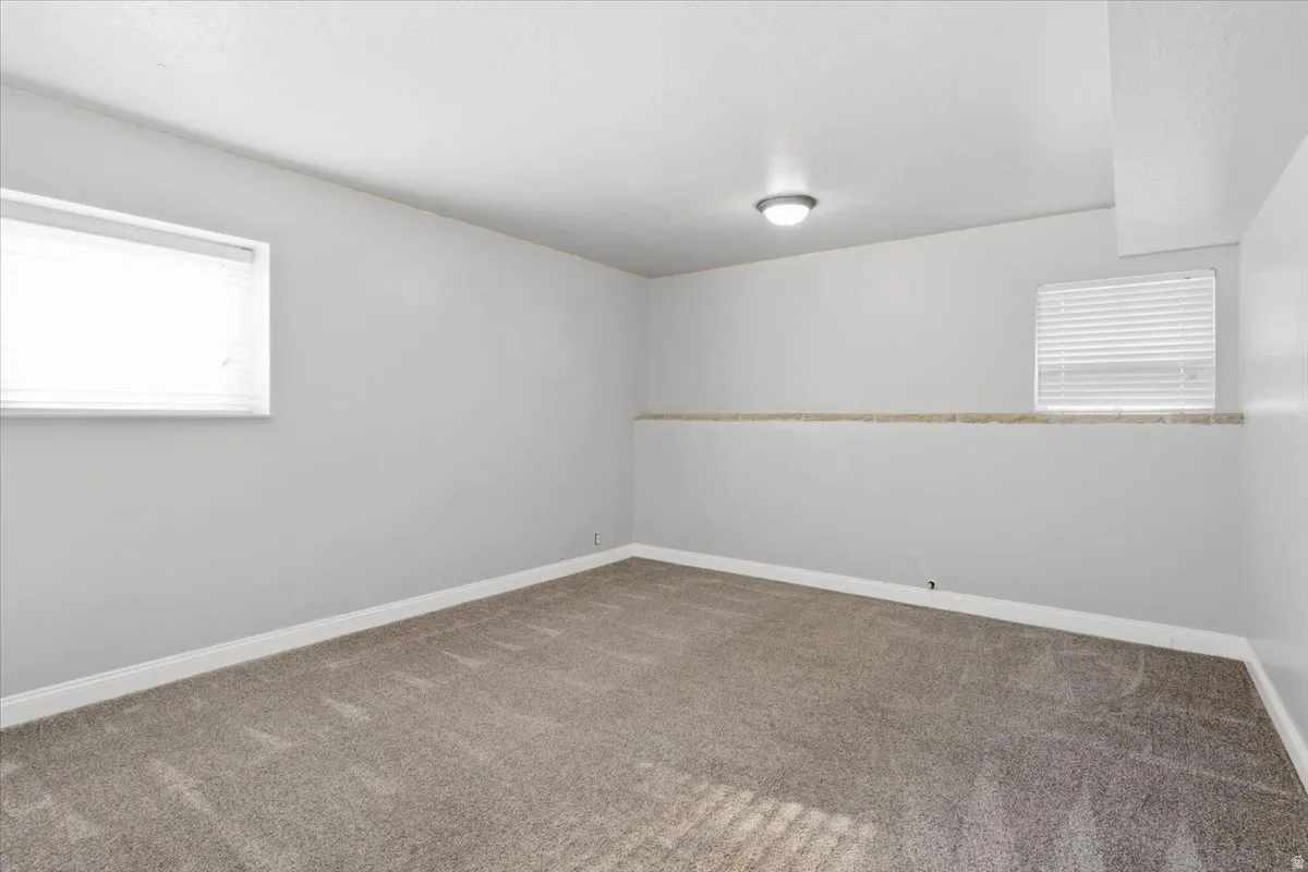 Recessed overhead lighting, light gray wall paint, and window treatments