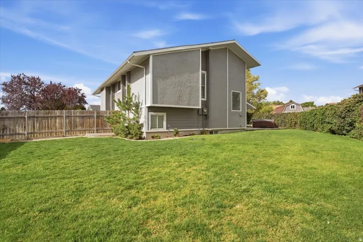 Expansive green lawn with a wood-fenced perimeter