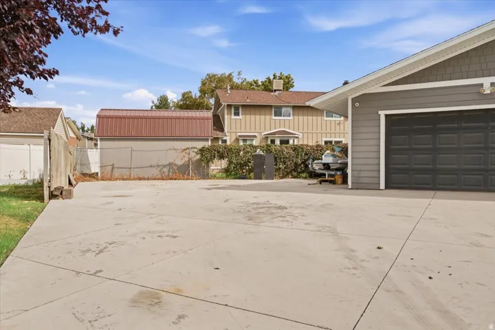 Paved driveway leading to a two-car garage with horizontal siding and shake siding accents