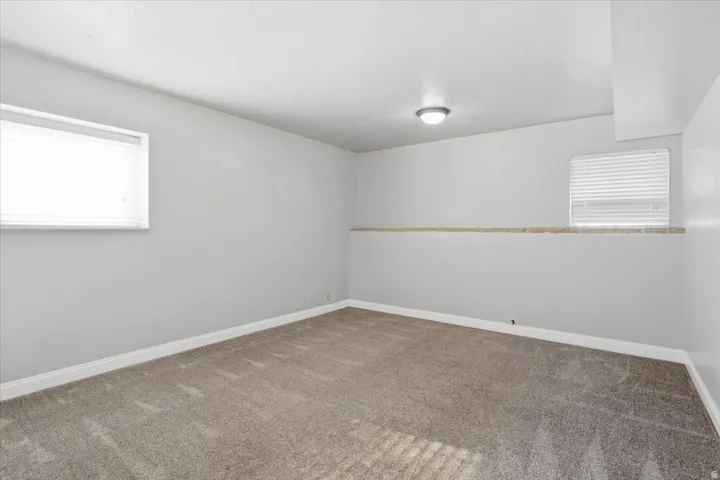 Recessed overhead lighting, light gray wall paint, and window treatments