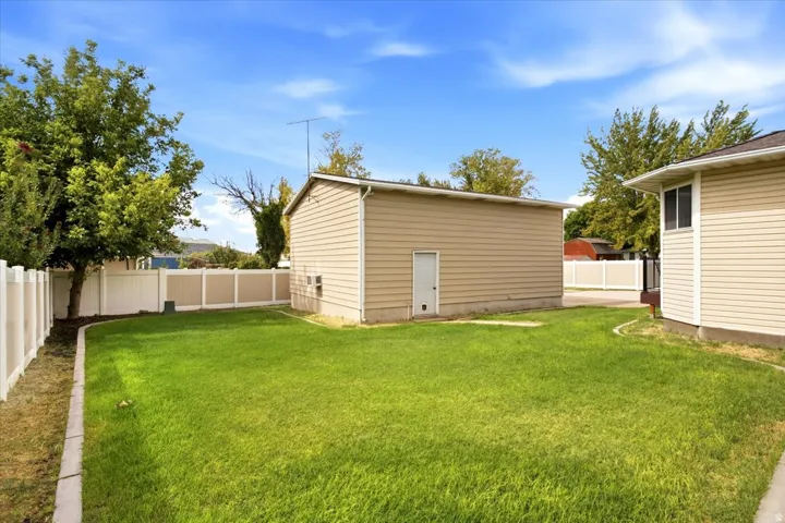 Expansive grassy yard area with a two-tone privacy fence