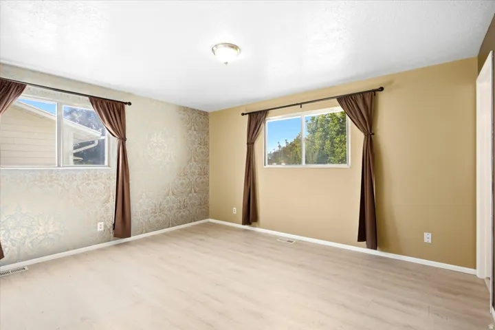 Light wood-finish flooring with a textured accent wall