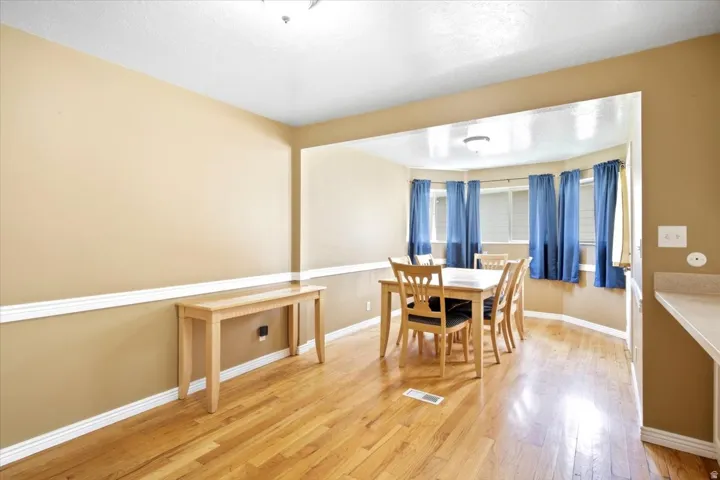 Hardwood-finish flooring, accent wall molding, recessed bay window, and built-in countertop extension