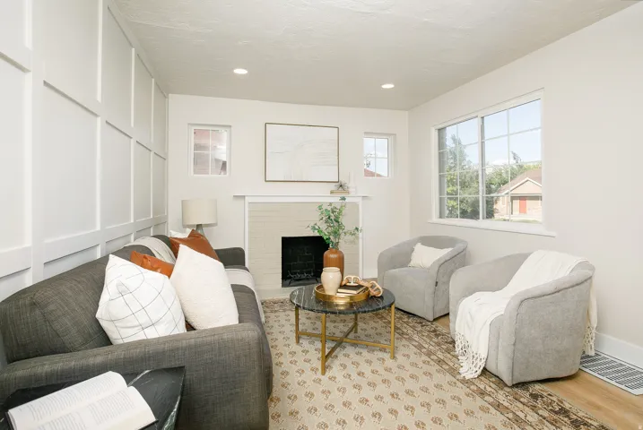 Board and batten accent wall, recessed lighting, double-pane window, single-pane window, and a fireplace with a light-toned brick surround
