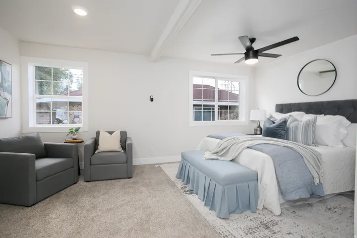 Recessed lighting, exposed beam accent, ceiling fan with integrated lighting, two windows, and carpeting
