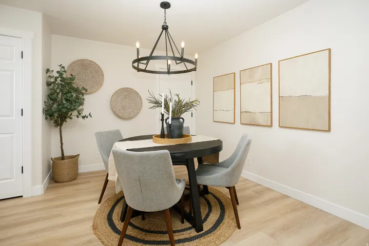 Wood-finish flooring with a neutral wall color, accented by a black metal chandelier