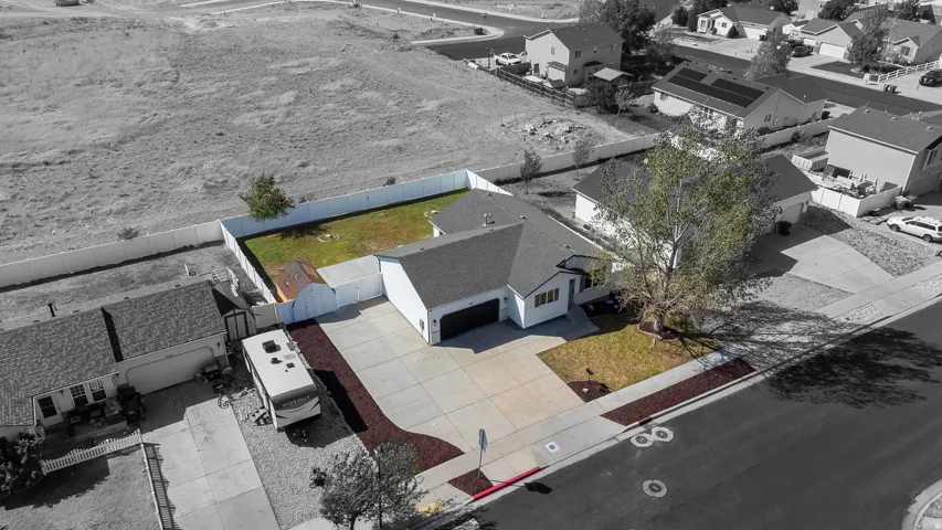 Single-story residence with an attached garage, paved driveway, and manicured landscaping