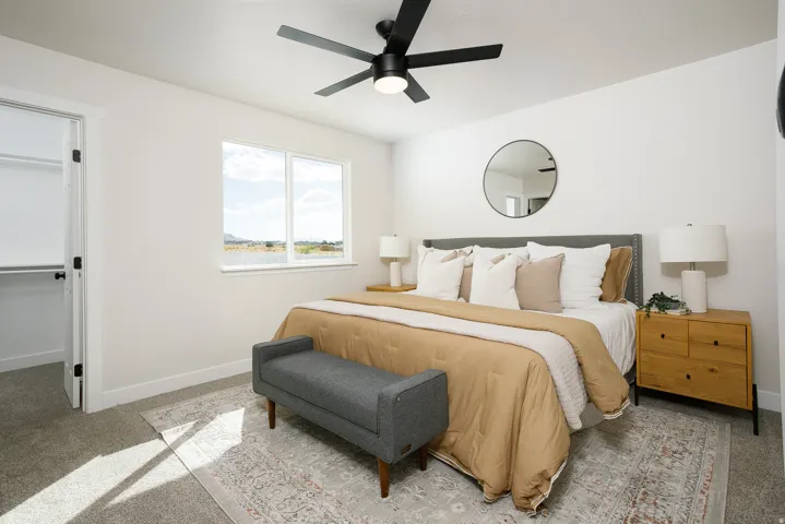 White walls with recessed window, black ceiling fan, and carpeted flooring