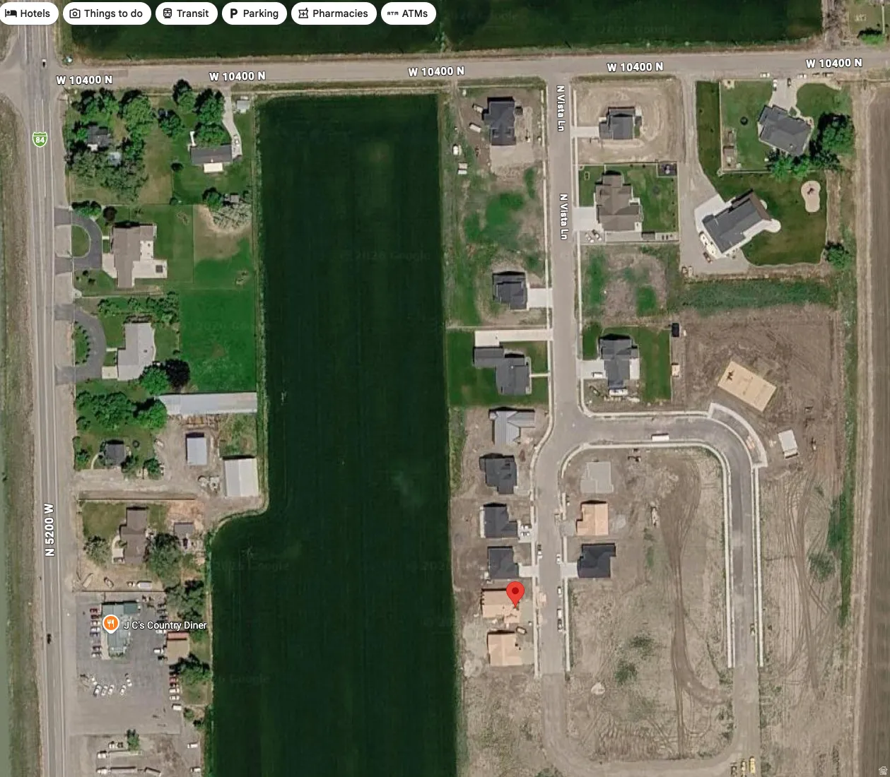 Satellite Map. Overview of a developed residential area with agricultural land and road networks