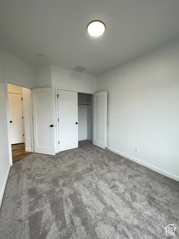 Bedroom 3, carpeted flooring, white shaker-style interior doors, and a built-in closet with integrated shelving