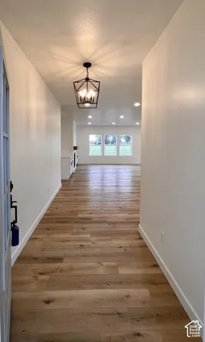 Entryway featuring wood-finish flooring, a geometric pendant light fixture, and recessed ceiling lighting