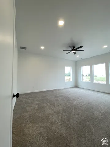 Primary Bedroom, Neutral-toned carpeted flooring, recessed lighting, matte black ceiling fan, and large windows